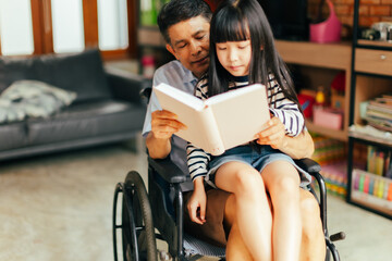 Senior asian male smiling and reading interesting fairytale to curious girl while sitting on sofa and resting together.