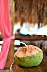 Fresh coconut water served in a strawed shell at an island restaurant 