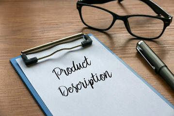 Selective focus of glasses,  pen, clipboard and paper written with Product Description on wooden background.
