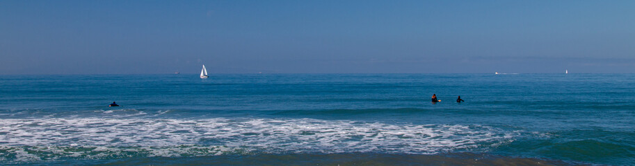 Surfers and Sailboat in the Pacific Ocean near Ventura California United States