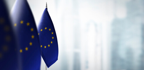 Small flags of European Union on a blurry background of the city © butenkow