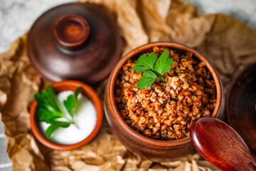 Buckwheat porridge with parsley in pot - breakfast, healthy food. Close up