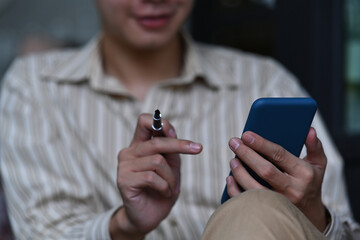 Cropped shot businessman holding pen and using smart phone.