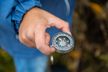 compass in hand, determining the direction in the forest