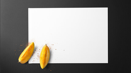 Ripe mango slice with spices on white paper on black background with copy space free image