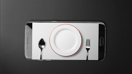 Cutlery screen on black smartphone on black background with copy space
