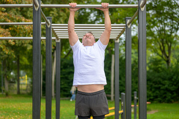 Man pulling himself up by his arms on parallel bars