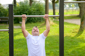 Senior man straining to pull himself up by the arms