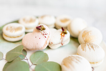 White macaroons are on a plate. Delicious light cookies on a plate on a light background. Bakery