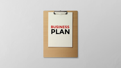 Business plan is written on a clipboard flat lay on the clean background with copy space