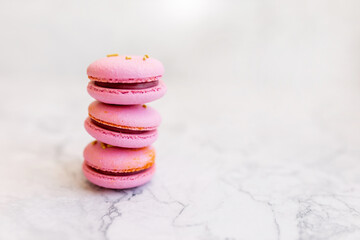 Pink macaroons on a light marble background. Delicious baked goods close-up
