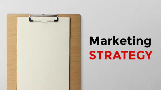 Marketing strategy is written beside of clipboard with copy space free image