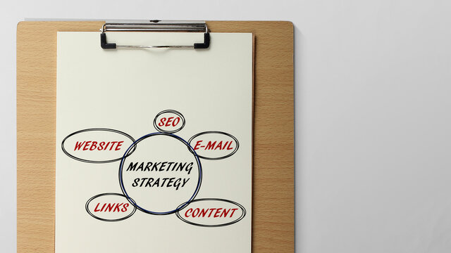 Marketing strategy written on clipboard in office work space with copy space free image