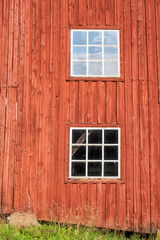 Obraz na płótnie Canvas Red wall with white windows on a barn