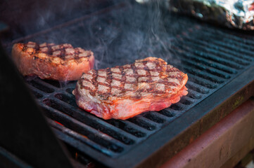 Beef steaks with vegetables on the grill with flames
