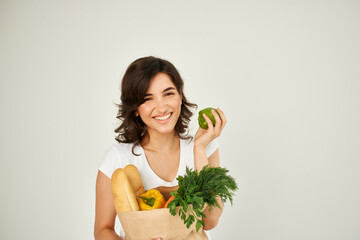 woman with package of groceries supermarket light background