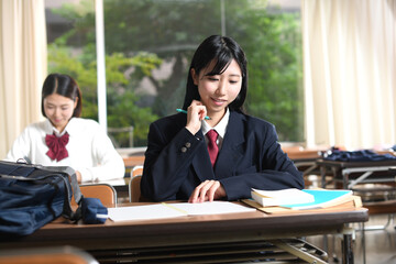 授業中に勉強をする女子学生のイメージ