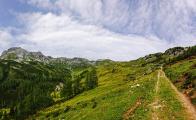 Fototapeta na wymiar gorgeous rocky mountain landscape with electricity pylons and soft clouds on the blue sky panorama