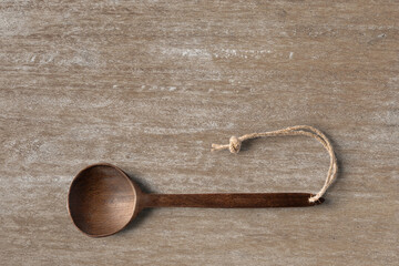Wooden cooking  spoon horizontally lying on clean wooden table top view shot, with space for text.
