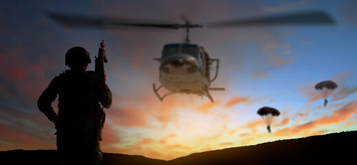 Silhouette Blur back side view soldier helicopter under army and parachute training at sunset...