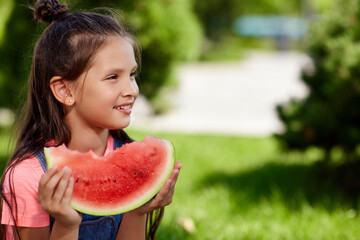 child girl eats a watermelon in sunny day