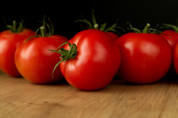 Fresh ripe tomatoes on a wooden kitchen table.