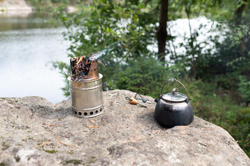 rest in the countryside in nature. Camping. A fire in a woodchip and a kettle.