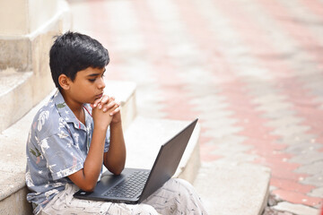 Portrait of Indian little boy using Laptop for online class	
