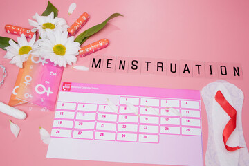 Menstruation calendar with cotton tampons , sanitary pads, white flower . Woman critical days, woman hygiene protection