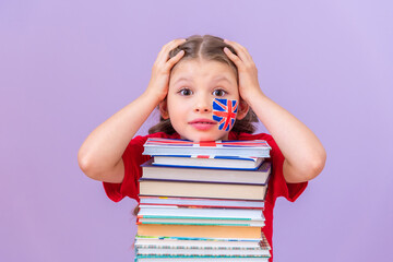 The girl is holding her head because of a difficult study, leaning on a stack of books.