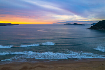 Colourful high cloud covered sunrise seascape