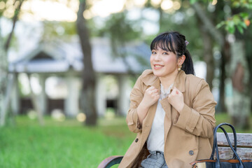 公園のベンチでガッツポーズする女性