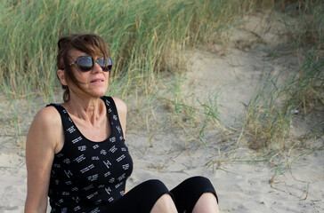 Jolie femme assise dans les dunes