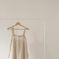 Women's aesthetic minimal fashion wardrobe concept with neutral pastel beige color overall dress or...