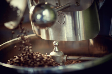 close up view of coffee beans roasting in machine