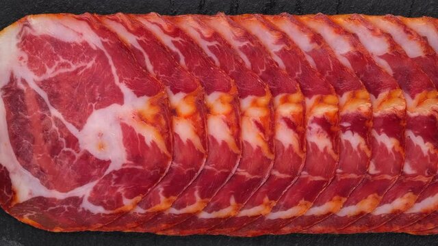 Sliced Spanish sausages Coppa or Capicola top view. Sliding shot. 4K UHD video 
