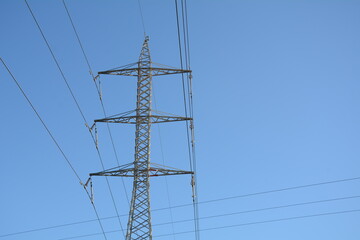 Electricity pylon in a field with blue sky. A transmission tower. High voltage tower
