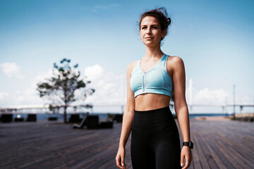 Fototapeta premium The trainer counts the pulse on a smart watch. Sports and clothing for women. Fitness break in the city. Cardio training for weight loss. The athlete leads a healthy lifestyle.