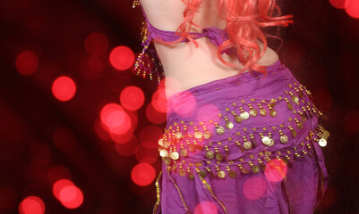 Naklejka premium Belly Dancer wearing purple dance costume close up with bokeh