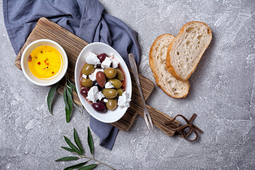 Bowl of delicious olives with Feta cheese in oil and bread