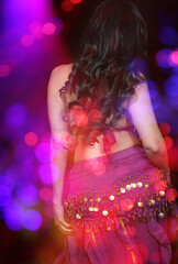 Belly Dancer wearing purple dance costume close up with bokeh