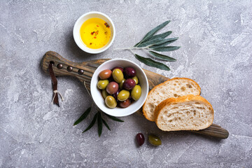 Bowl of delicious olives with oil and bread