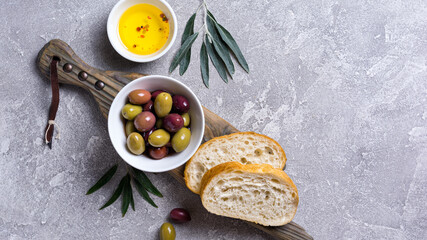 Obraz na płótnie Canvas Bowl of delicious olives with oil and bread
