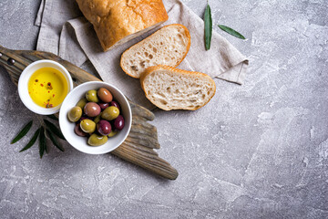 Bowl of delicious olives with oil and bread