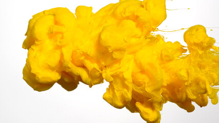 Drops of yellow ink in water. Yellow watercolor ink in water on a white background. Colored acrylic paints in water. Yellow cloud of ink on a white background.