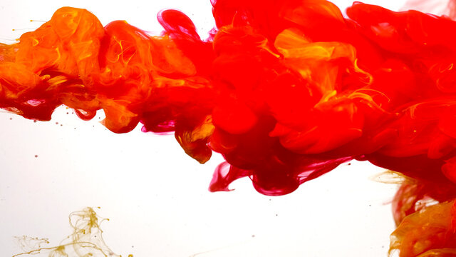 Red and yellow watercolor ink in water on a white background. Colored acrylic paints in water. Red-yellow cloud of ink on a white background. Beautiful abstract background.