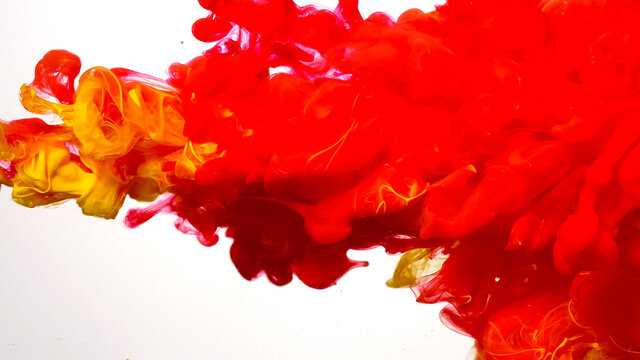 Colored acrylic paints in water. Red-yellow cloud of ink on a white background. Beautiful abstract background. Drops of red-yellow ink in water.