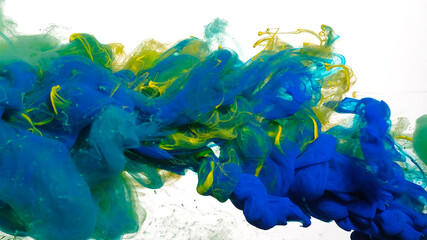 Colored cloud of ink on a white background. Blue, green and yellow watercolor ink in water on a white background. Beautiful abstract background.