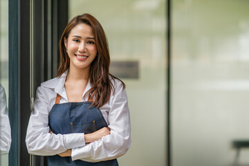 Fototapeta premium Beautiful young woman portrait. Smiling businesswoman with crossed arms.