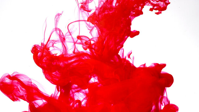 Red watercolor ink in water on a white background. Beautiful abstract background. Blood red acrylic paints mix in water.